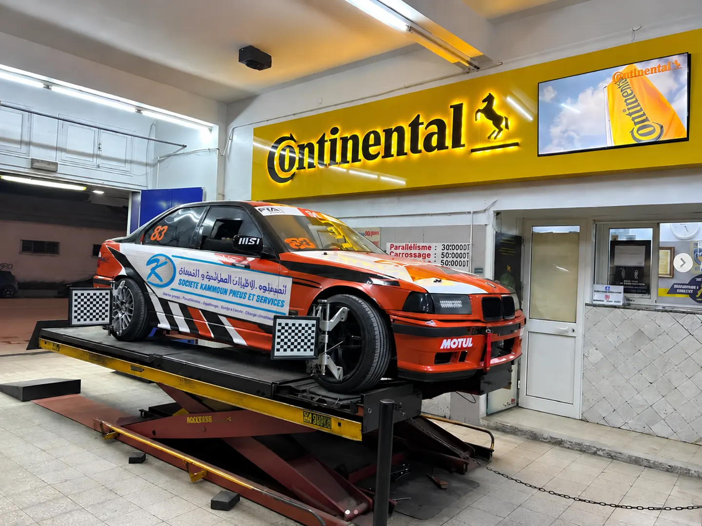 The S.K.P.S-sponsored BMW race car on the 3D alignment lift